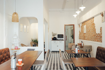 The image shows an interior view of a modern cafe or restaurant in Thao Dien, Saigon. The space features white walls with decorative elements such as
