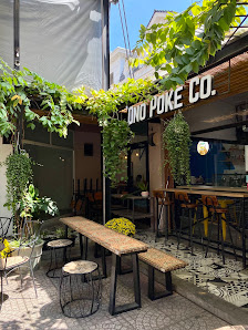 The image shows an exterior view of a restaurant named 'ONO POKE CO.' with outdoor seating arrangements including tables and benches, surrounded by gr