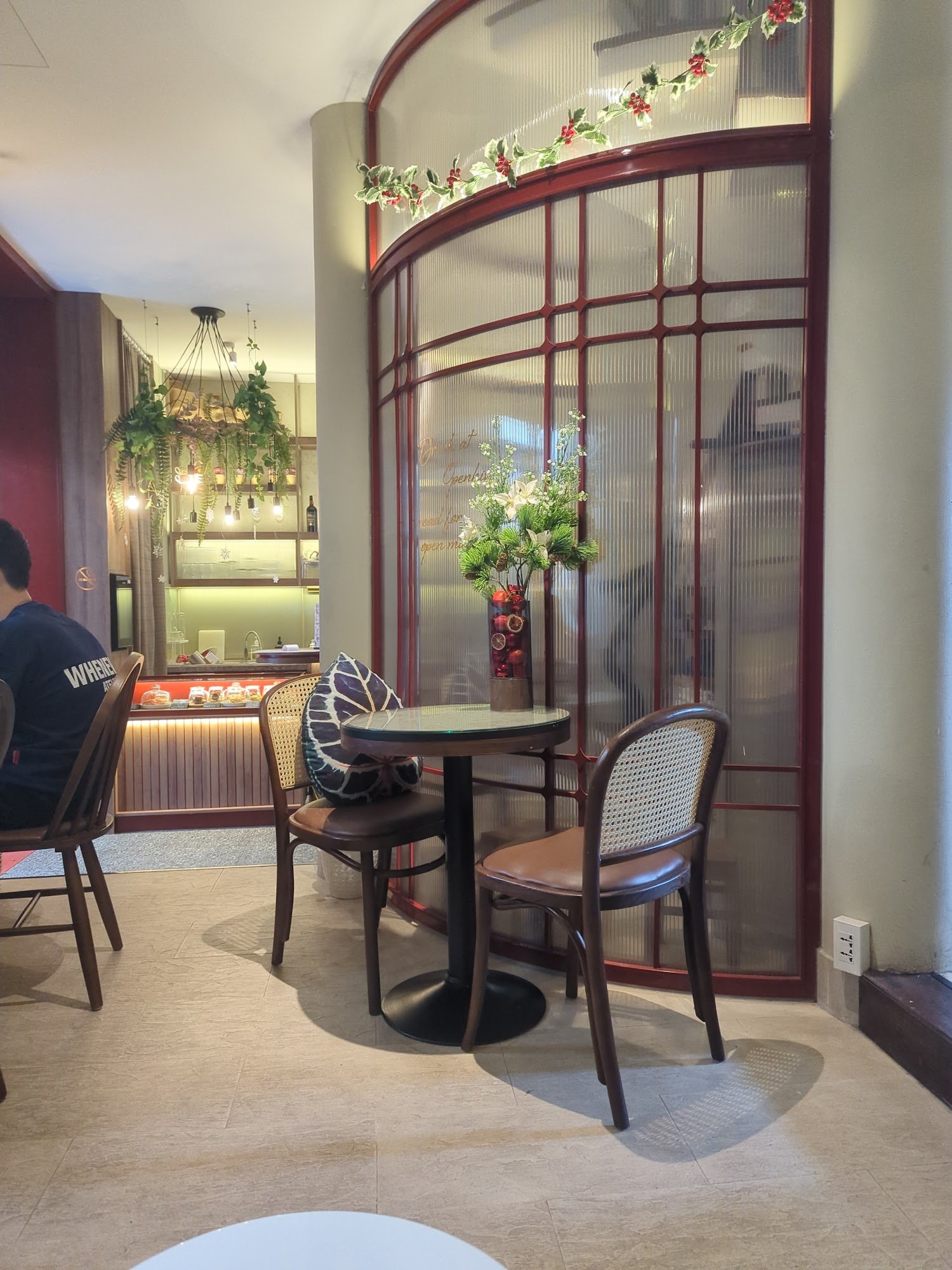 The image shows an indoor setting of a restaurant or cafe in Thao Dien, Saigon. The decor includes wooden chairs with cushioned seats and metal frames