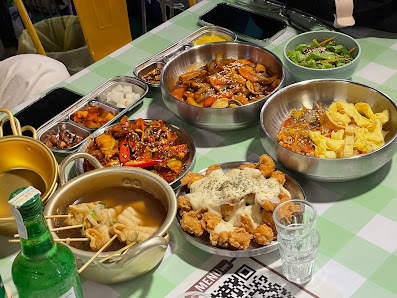 A selection of Asian-style dishes including stir-fried noodles, fried chicken with sauce, and a vegetable salad.