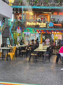 The image shows an exterior view of a restaurant named 'Pacho Pocha' with outdoor seating and neon signs in the background.