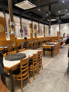The image depicts the interior of a restaurant in Thao Dien, Saigon. It features multiple wooden tables and chairs arranged in rows, with some tables 
