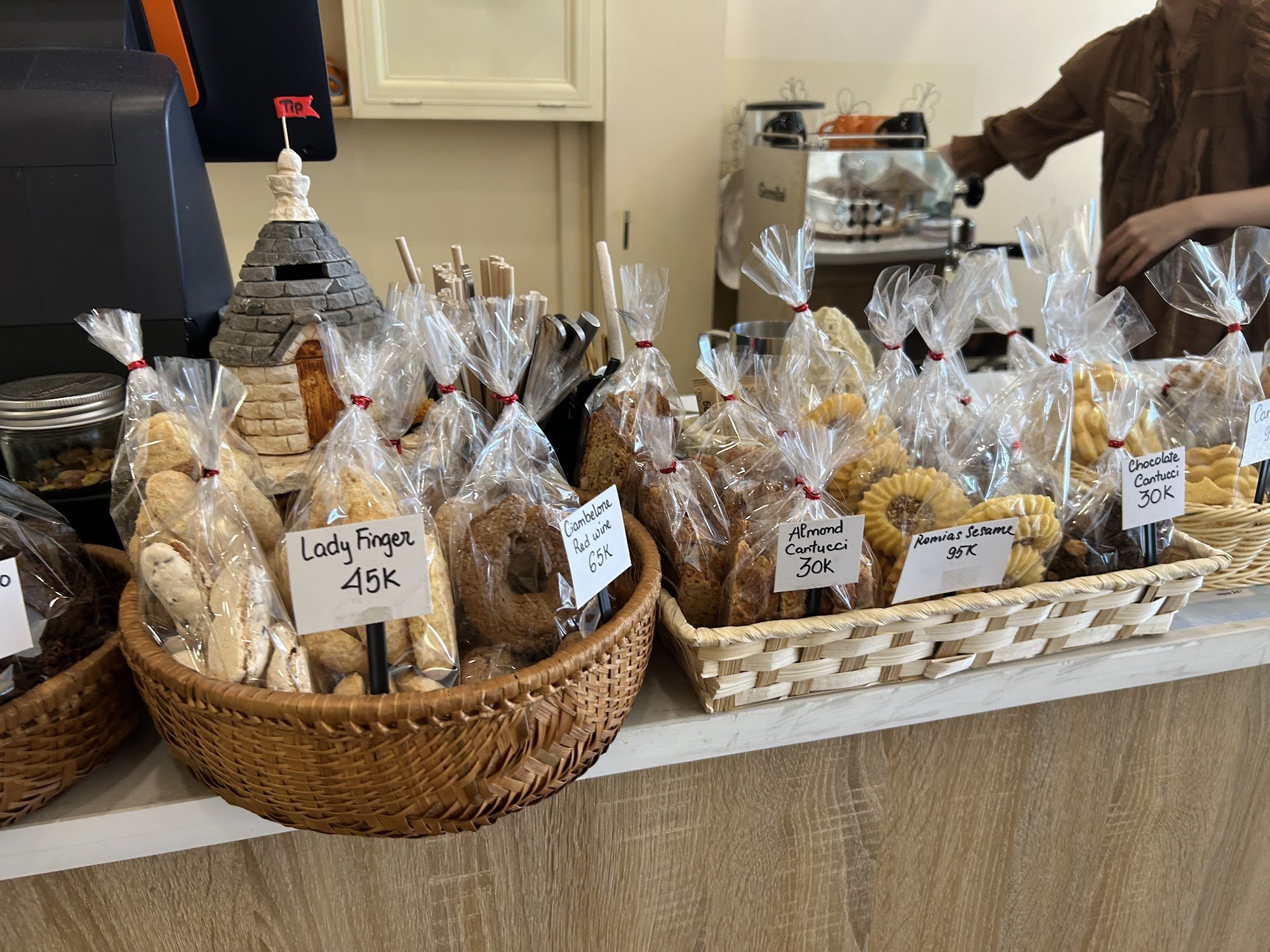 The image shows a counter in what appears to be a café or bakery shop within Thao Dien, Saigon. Various baked goods are displayed for sale on the coun