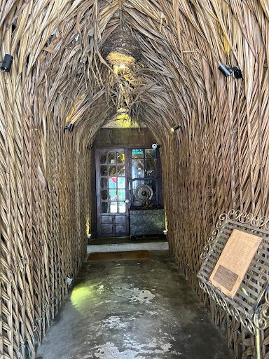 The image depicts an interior space that appears to be a narrow corridor leading towards a door at the end of it. The walls and ceiling are constructe