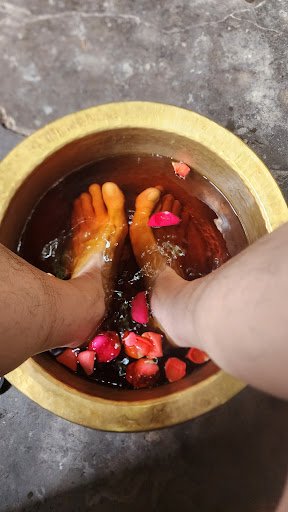 A close-up view of a person's feet immersed in a traditional foot bath within an interior setting that appears to be Thao Dien, Saigon.