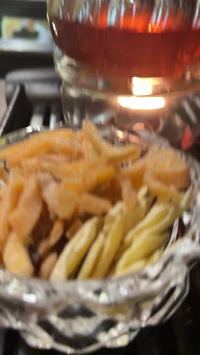 A close-up of a glass bowl containing sliced fruits and nuts, possibly served as a snack or appetizer.