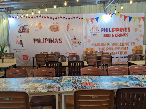 The image shows an indoor dining area decorated for a Filipino-themed event or restaurant named 'Pilipinas'. The decor includes colorful banners with