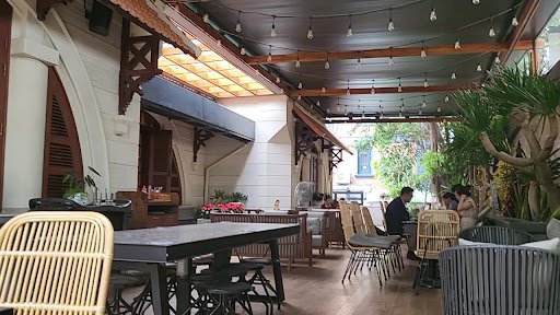The image shows an indoor dining area of a restaurant or café in Thao Dien, Saigon. The space is well-lit with natural light coming through the window