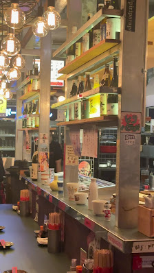 The image shows an interior view of a restaurant or food establishment in Thao Dien, Saigon. The counter area is visible with various items such as bo