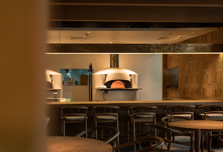 The image depicts the interior of a modern café or restaurant in Thao Dien, Saigon. It features a row of high-backed chairs with dark frames and light