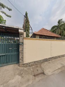 The image shows a residential area in Thao Dien, Saigon. It features a gated entrance with green metal gates and a beige wall fence surrounding the pr