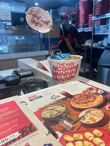 The image shows a section of an interior at Thao Dien, Saigon, featuring a food counter with various items on display including pizza and chicken wing
