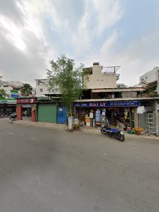 The image shows a street view of an urban area in Thao Dien, Saigon with various shops and stalls on the side of the road.
