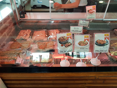 The image depicts the interior of a food venue in Thao Dien, Saigon, showcasing a glass display case filled with various packaged food items, includin
