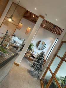 The image depicts the interior of a modern venue in Thao Dien, Saigon. Key elements include a sleek glass-fronted counter on the left, wooden ceiling 