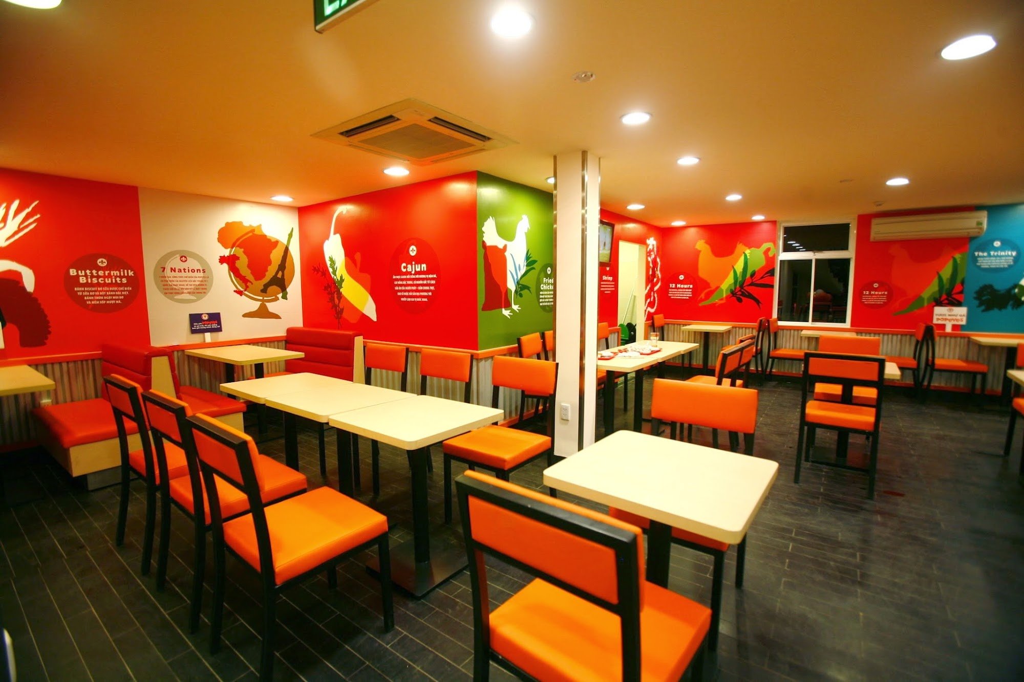 A brightly lit restaurant interior with vibrant red, green, and blue walls featuring thematic murals (e.g., "Buttermilk Biscuits," "Cajun," "7 Nations