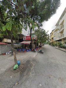 The image shows an outdoor street view of a residential area in Thao Dien, Saigon with buildings on both sides and people sitting outside at tables.