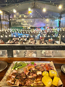 The image depicts the interior of a restaurant in Thao Dien, Saigon. In the foreground, there's a wooden counter with a platter of food including gril