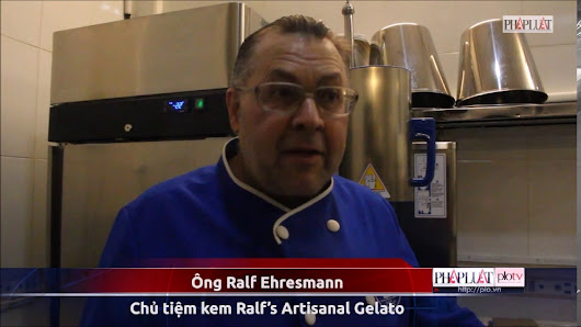 A man in a chef's uniform is standing in what appears to be a kitchen or food preparation area.