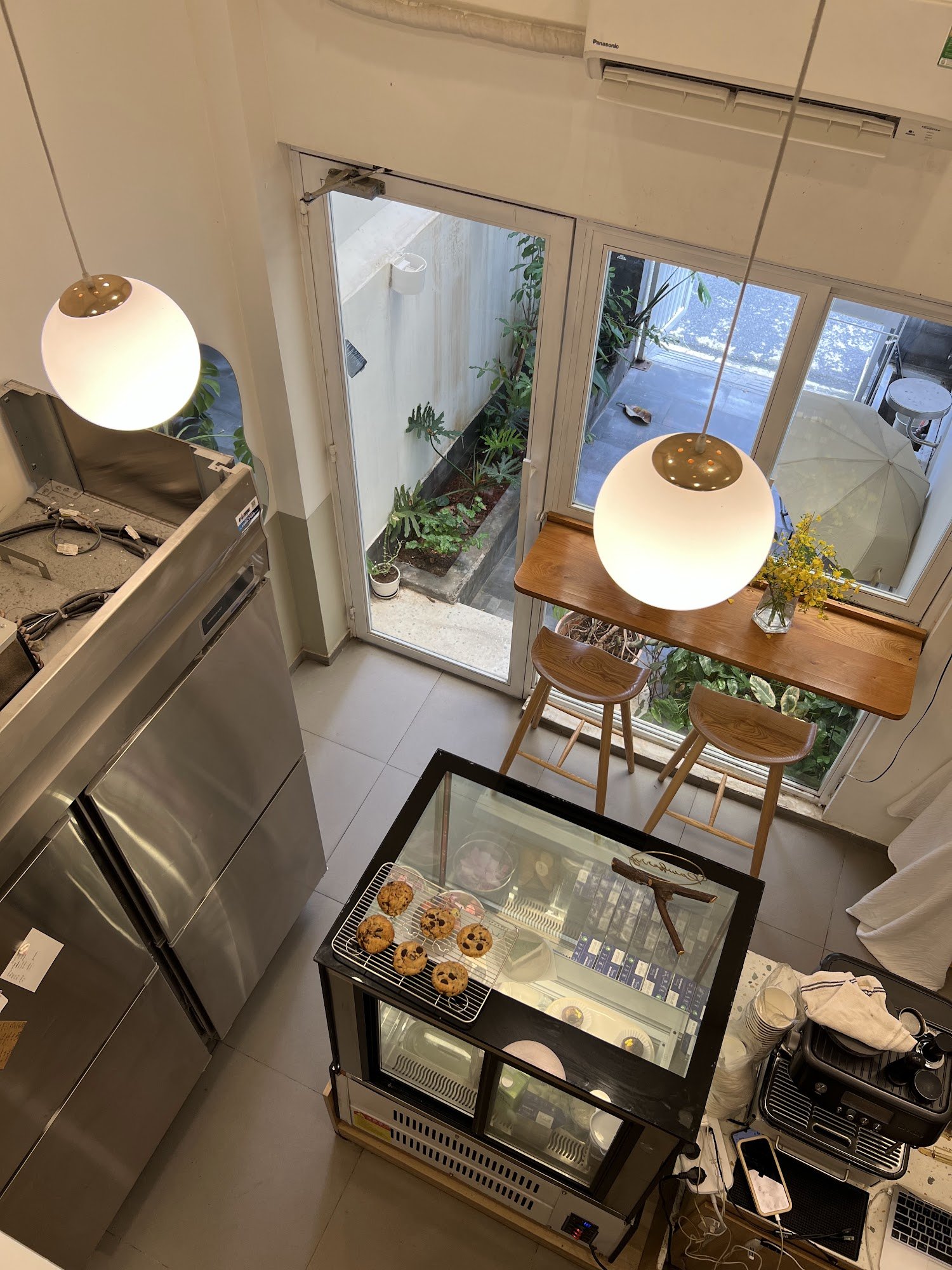 This image shows an interior view of a modern cafe or bakery located in Thao Dien, Saigon. The space is well-lit with natural light coming through the