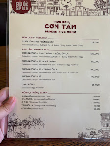 A person is holding a menu from 'Rouge Spice' restaurant in Thao Dien, Saigon which features Vietnamese cuisine with various dishes listed including p