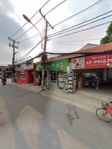 The image shows a street view of an exterior scene featuring multiple storefronts including a pharmacy and what appears to be a convenience store with