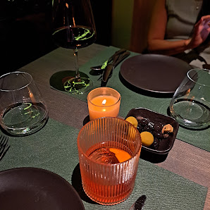 A dimly lit dining table set for a meal at Thao Dien, Saigon with various dishes and drinks on it.