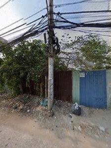 The image shows an outdoor scene featuring a utility pole and electrical wires in the foreground with various objects such as a blue gate, green folia