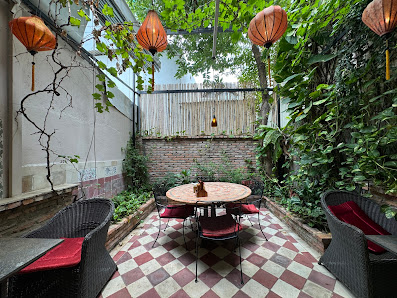 This image depicts an interior space that appears to be a cozy outdoor dining area within Thao Dien, Saigon. The flooring is checkered with red and wh