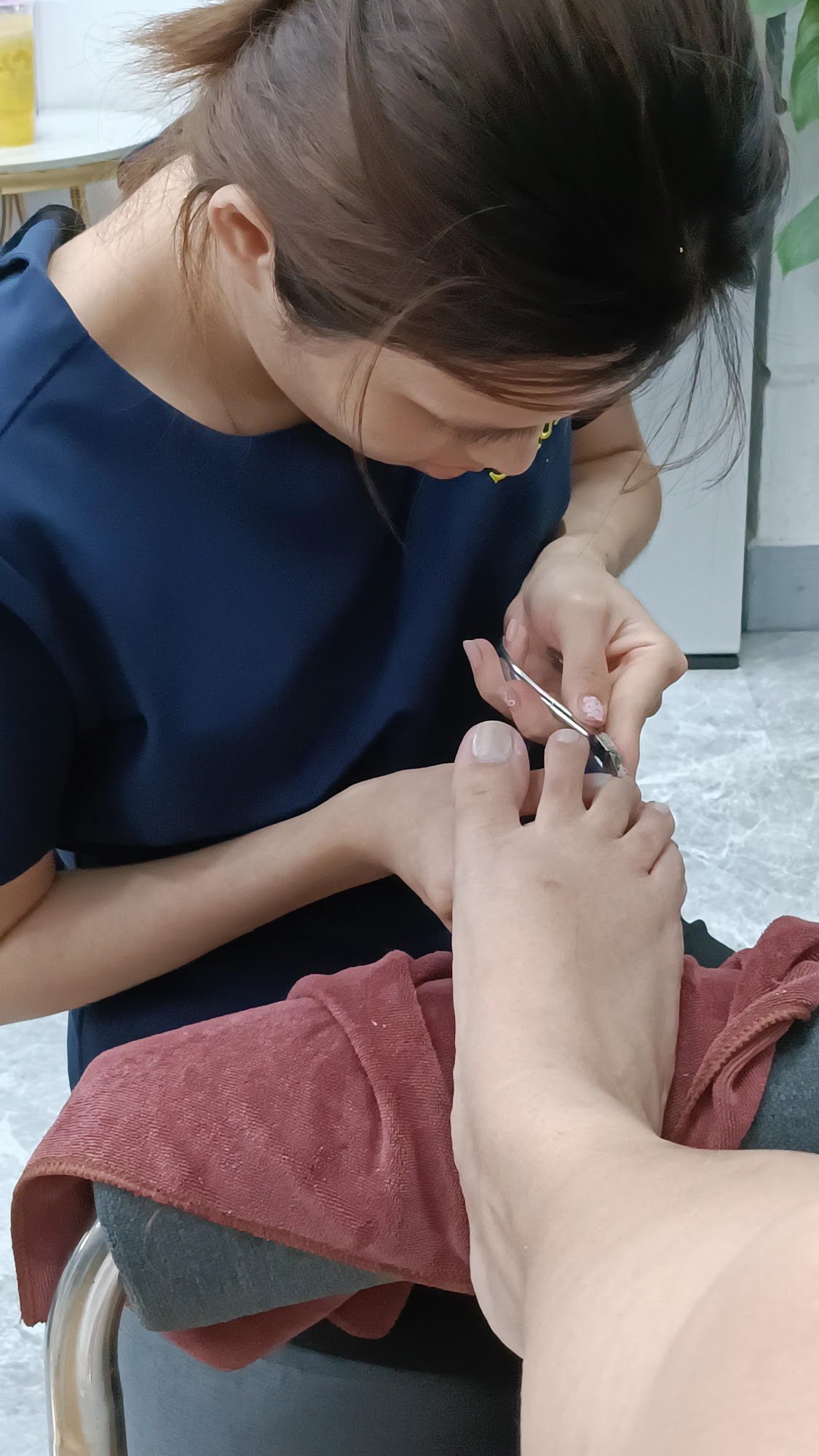 A person is receiving a pedicure in an indoor setting.