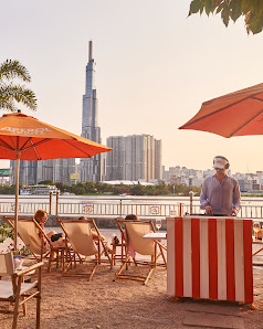 The image depicts an outdoor setting at Thao Dien in Saigon during what appears to be late afternoon or early evening, with a clear sky and warm light