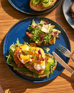 The image shows a plated dish consisting of what appears to be open-faced sandwiches or toast with various toppings such as greens, cheese, and possib