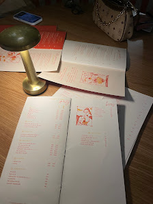 The image shows a desk cluttered with various documents and papers that appear to be related to some form of study or work, including what looks like 