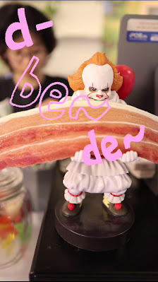 A playful and whimsical decoration featuring a clown figure on top of what appears to be a seesaw or balance beam, with the word 'booster' written in 