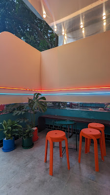 The image shows an interior space of a venue in Thao Dien, Saigon with modern decor featuring orange and blue lighting accents on the walls.