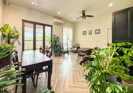 The image depicts a well-lit living room or dining area in an apartment located at Thao Dien, Saigon. The space features hardwood flooring with a herr