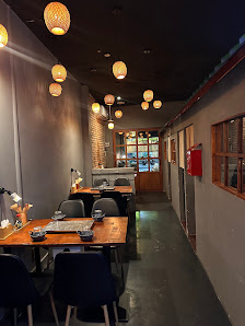 The image shows an indoor dining area of a restaurant or cafe in Thao Dien, Saigon. The space is dimly lit with warm lighting provided by hanging lant