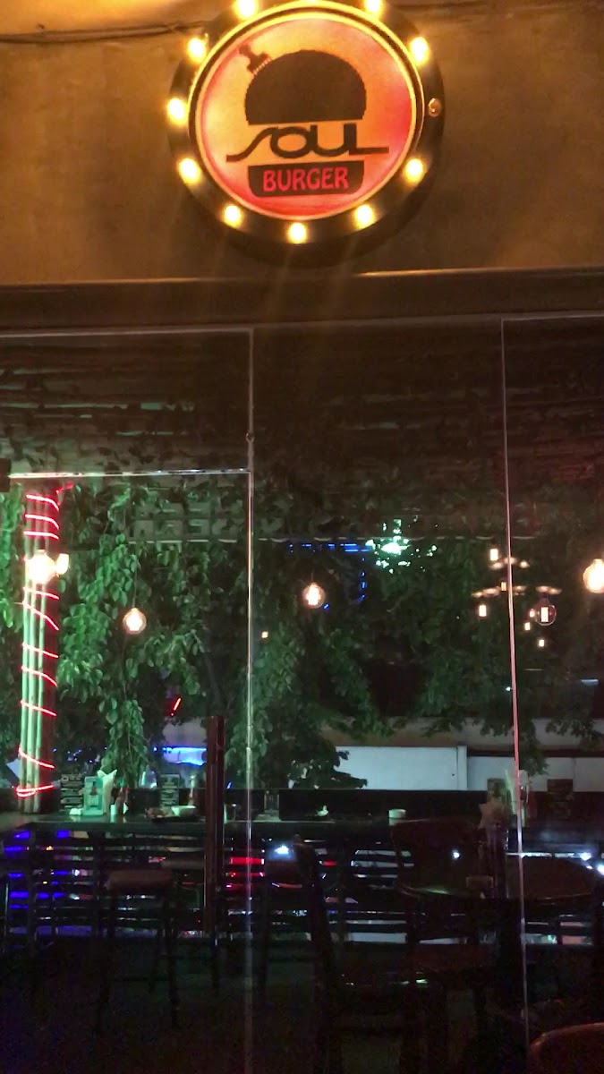 The image shows an interior view of a burger restaurant named 'SOUL BURGER'. The establishment has a modern and cozy ambiance with dim lighting, highl