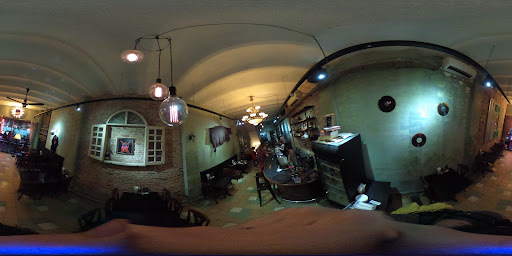 The image depicts the interior of a venue in Thao Dien, Saigon. It features a mix of brick walls, arched ceilings, and various lighting fixtures inclu