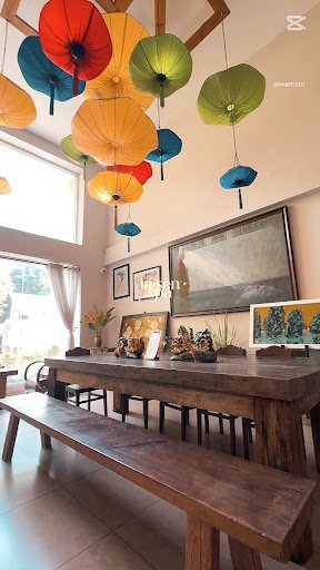 This image depicts an interior space that appears to be a dining area within a residential or commercial building. The room is well-lit with natural l