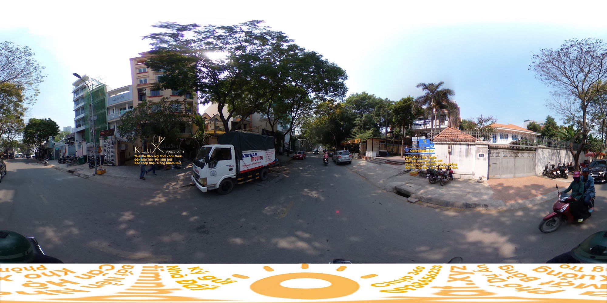 This image captures a street scene in Thao Dien, Saigon during the daytime with clear skies and moderate traffic. A white moving truck labeled 'Vietna