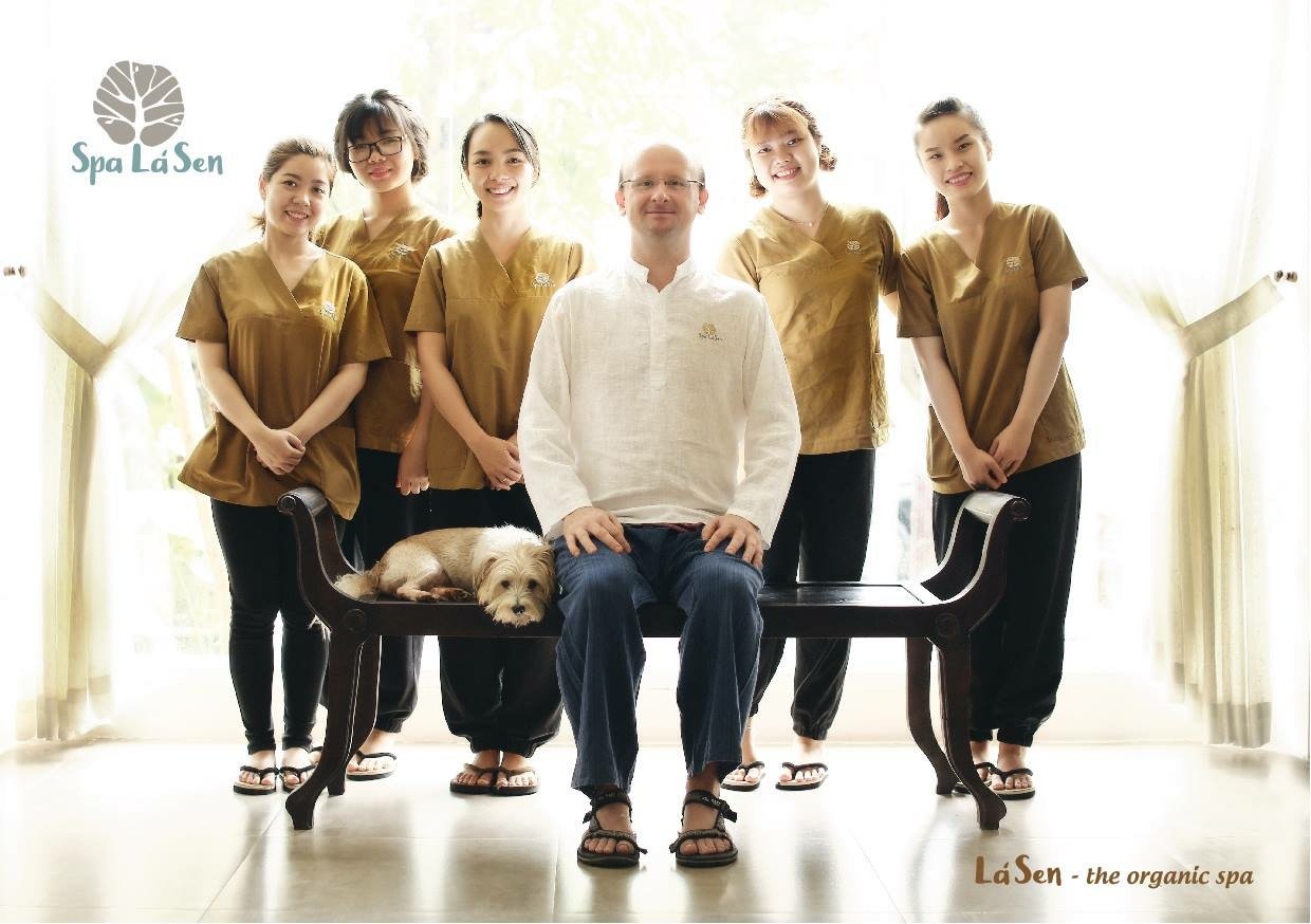 A group photo of staff members from Spa La Sen posing in a well-lit room with large windows behind them.