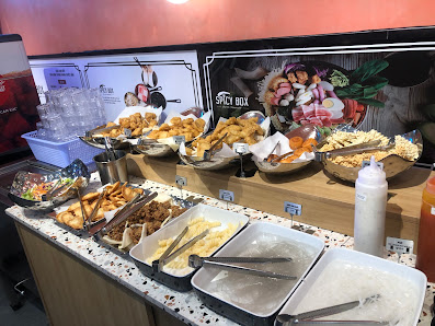 A food counter in a venue, likely a restaurant or food stall in Thao Dien, Saigon. The counter displays various dishes in trays and bowls, including f