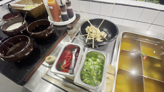 The image depicts the interior of a restaurant, likely a hot pot or communal dining venue in Thao Dien, Saigon. Visible elements include multiple brow