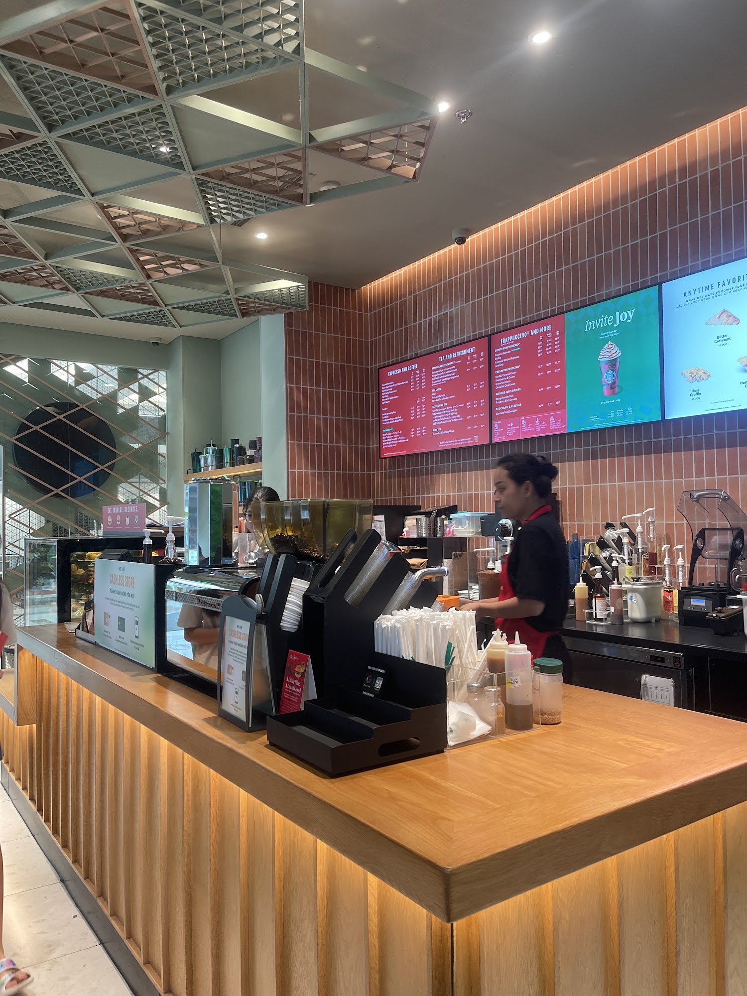 The image shows an interior view of a coffee shop or fast-food restaurant at Thao Dien, Saigon. The counter is well-organized with various beverage di