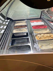 The image shows a display case in an establishment that contains various frozen desserts such as ice cream and sorbets.