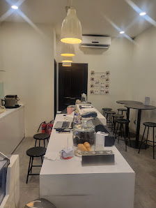 The image shows an interior view of a modern cafe or restaurant in Thao Dien, Saigon. The space is well-lit with overhead pendant lights and features 