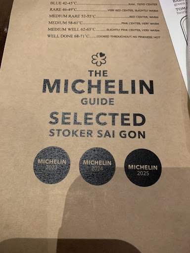 The image shows a brown paper menu from The Michelin Guide for selected stoker sai gon in Thao Dien, Saigon.