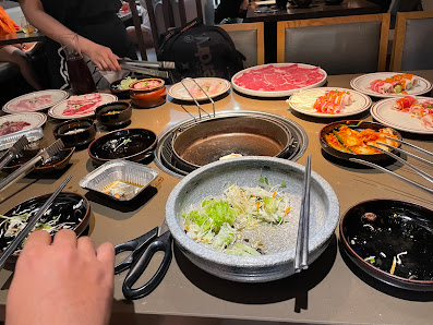 A dining table set for a hot pot meal at Thao Dien, Saigon with various dishes and ingredients laid out on the table.
