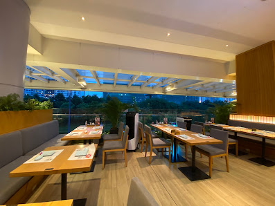 The image shows an interior view of a modern restaurant or dining area in Thao Dien, Saigon. The space features wooden flooring and tables with white